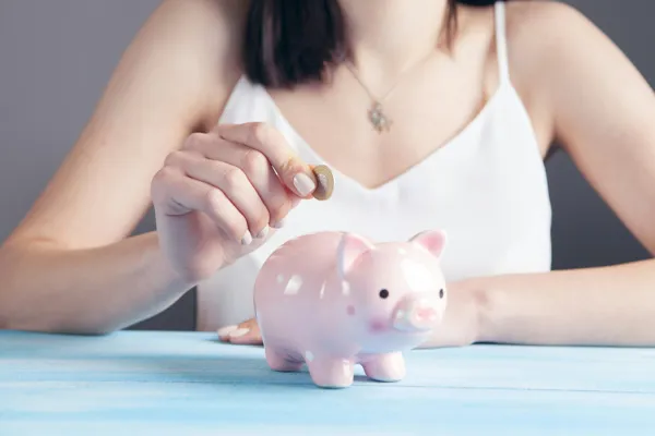 woman-putting-coin-in-piggy-bank.jpg