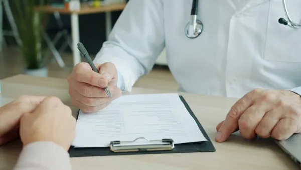 doctor-writing-on-paper.jpg