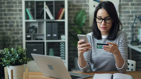 woman-looking-at-credit-card-and-phone.jpg