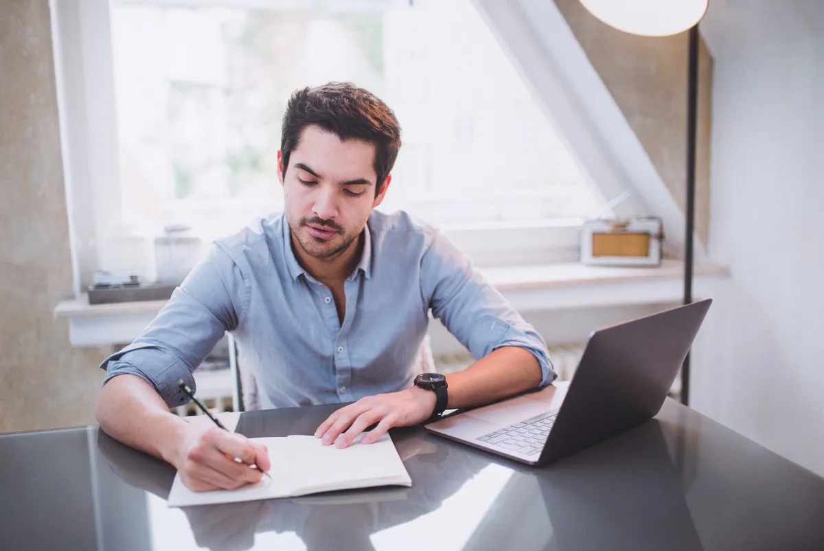 young-man-os-taking-some-notes-at-his-desk_t20_vK4J6j.jpg